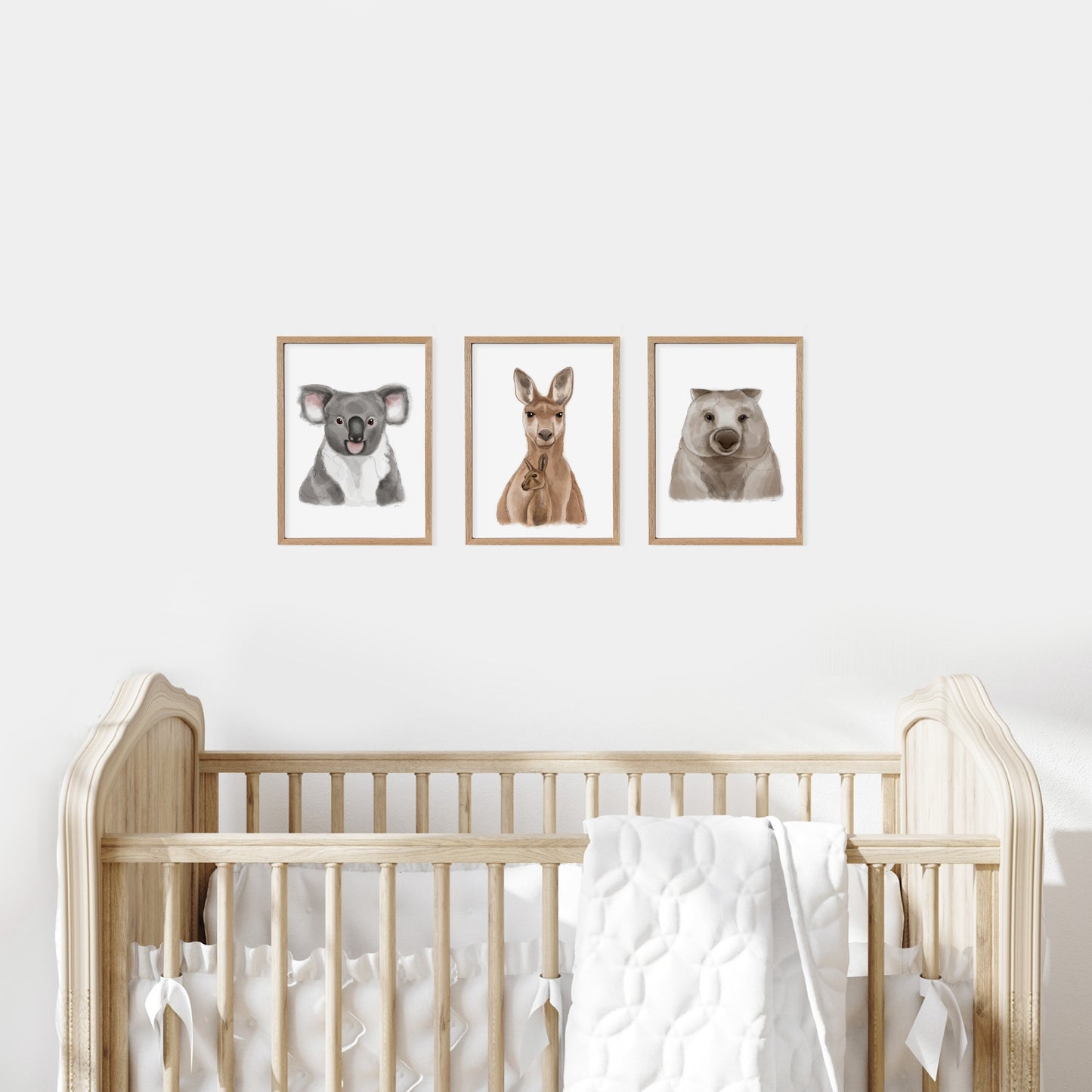 Nursery room with a wooden cot and wall art of a koala, kangaroo, and wombat.