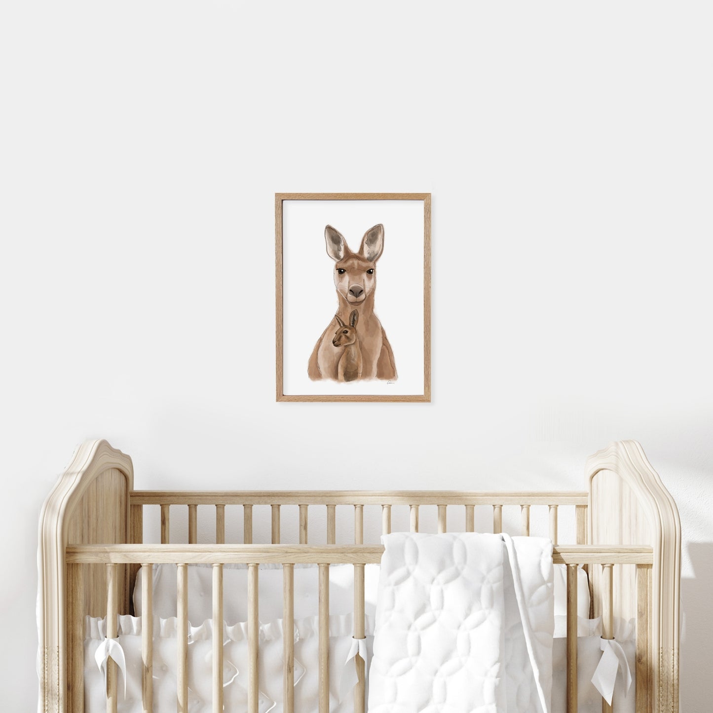 Framed illustration of a kangaroo on a wall above a cot in a baby nursery.