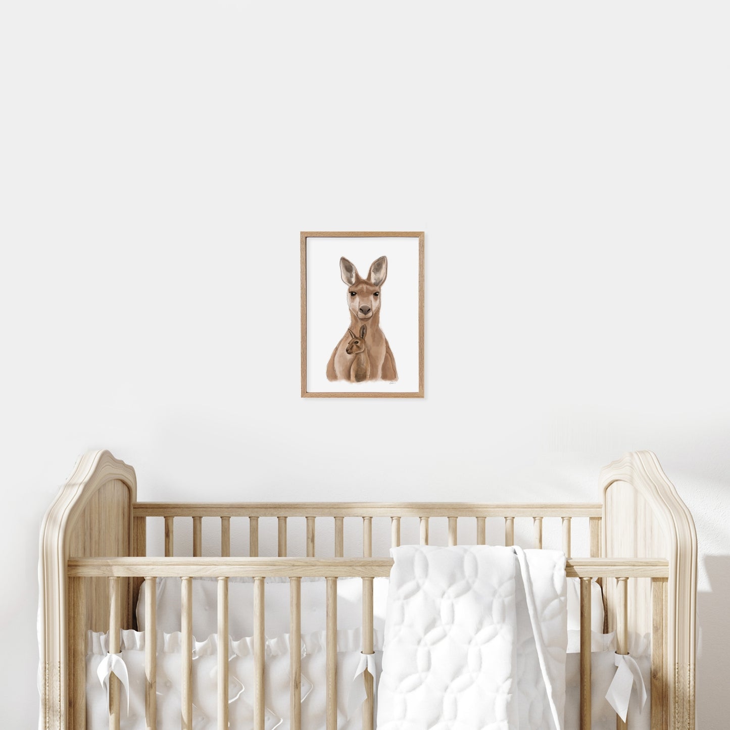 Framed illustration of a kangaroo on a wall above a cot in a baby nursery.