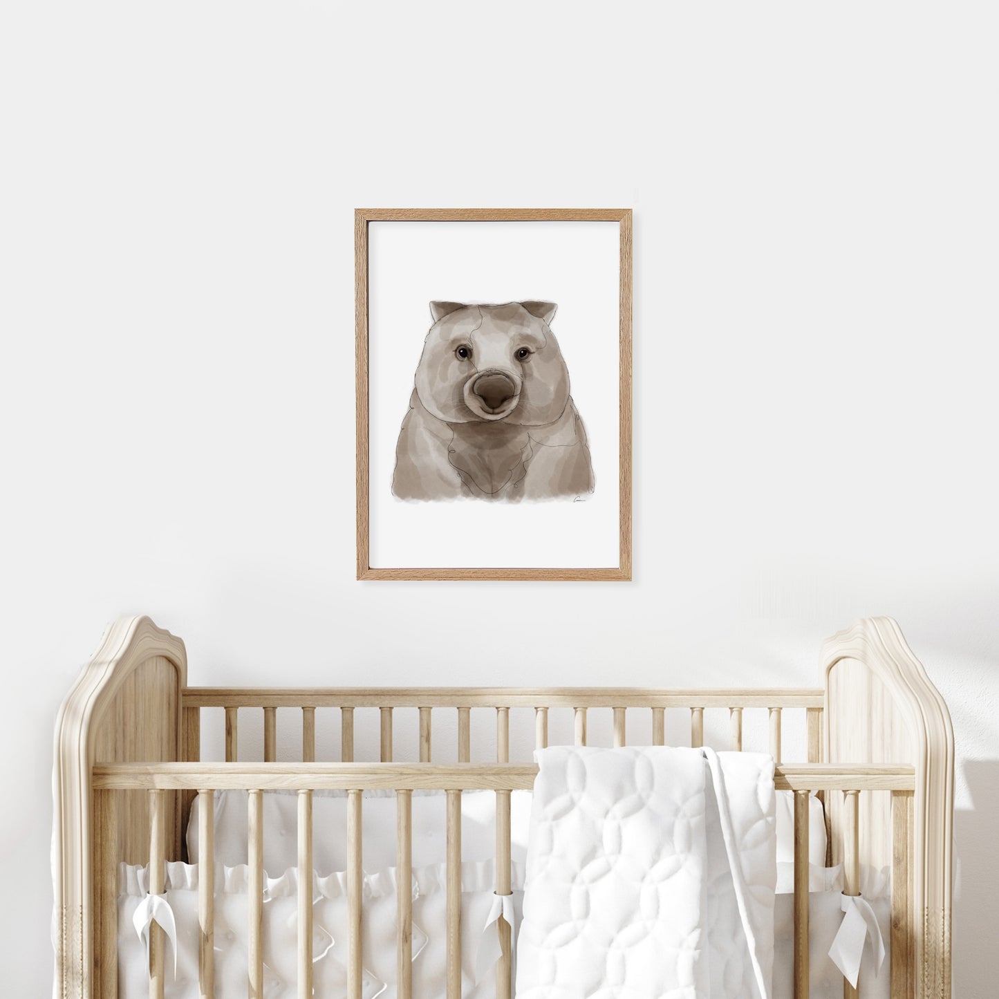 Framed illustration of a wombat on a wall above a cot in a baby nursery.