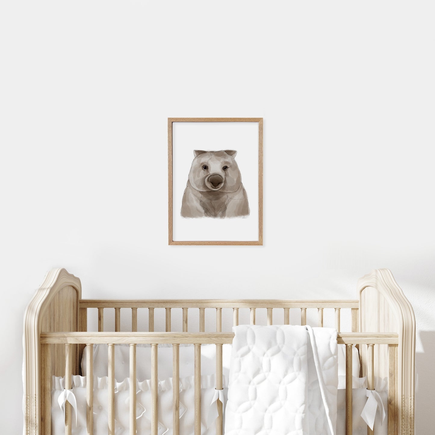 Framed wombat of a koala on a wall above a cot in a baby nursery.