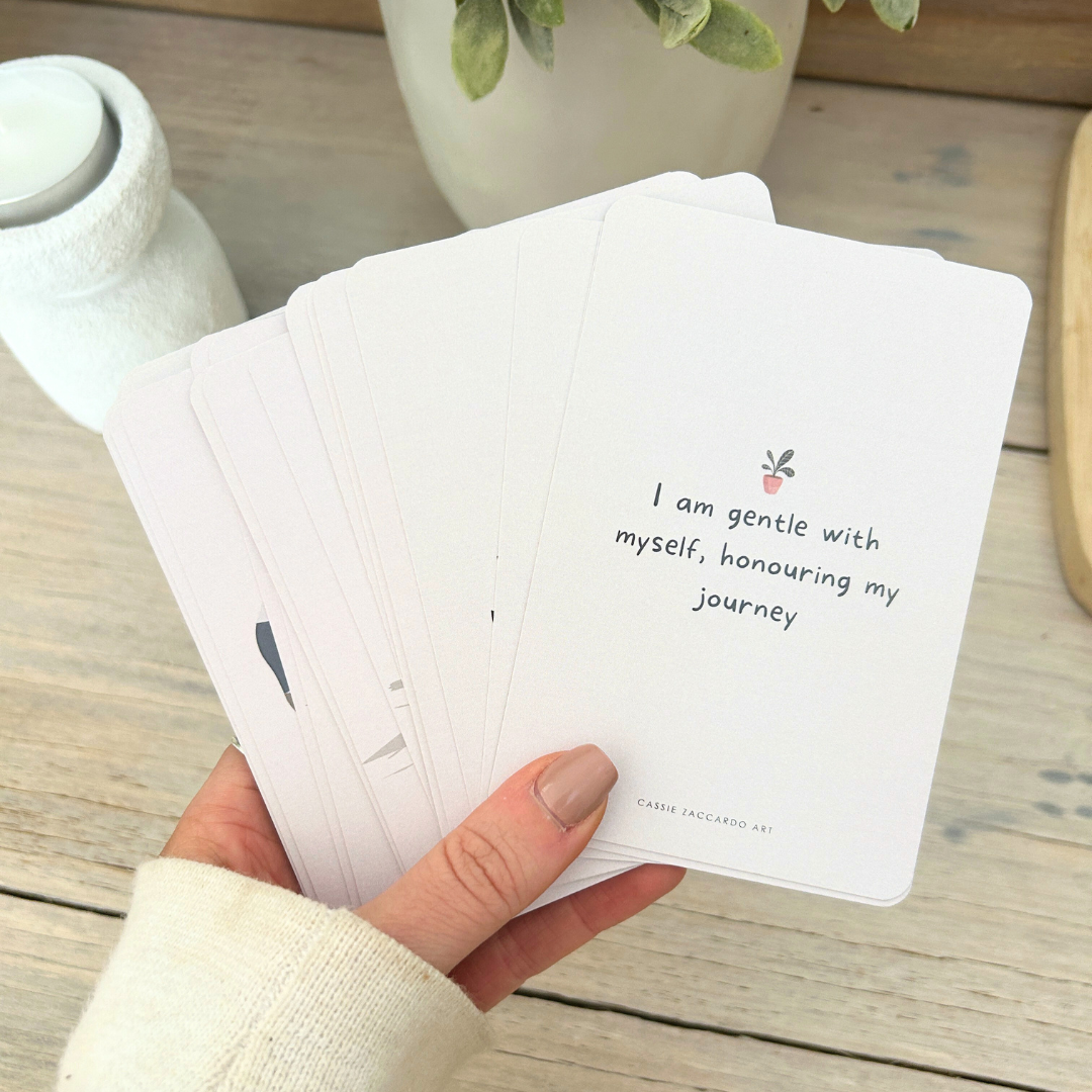 Daily affirmation card deck in hands with quotes