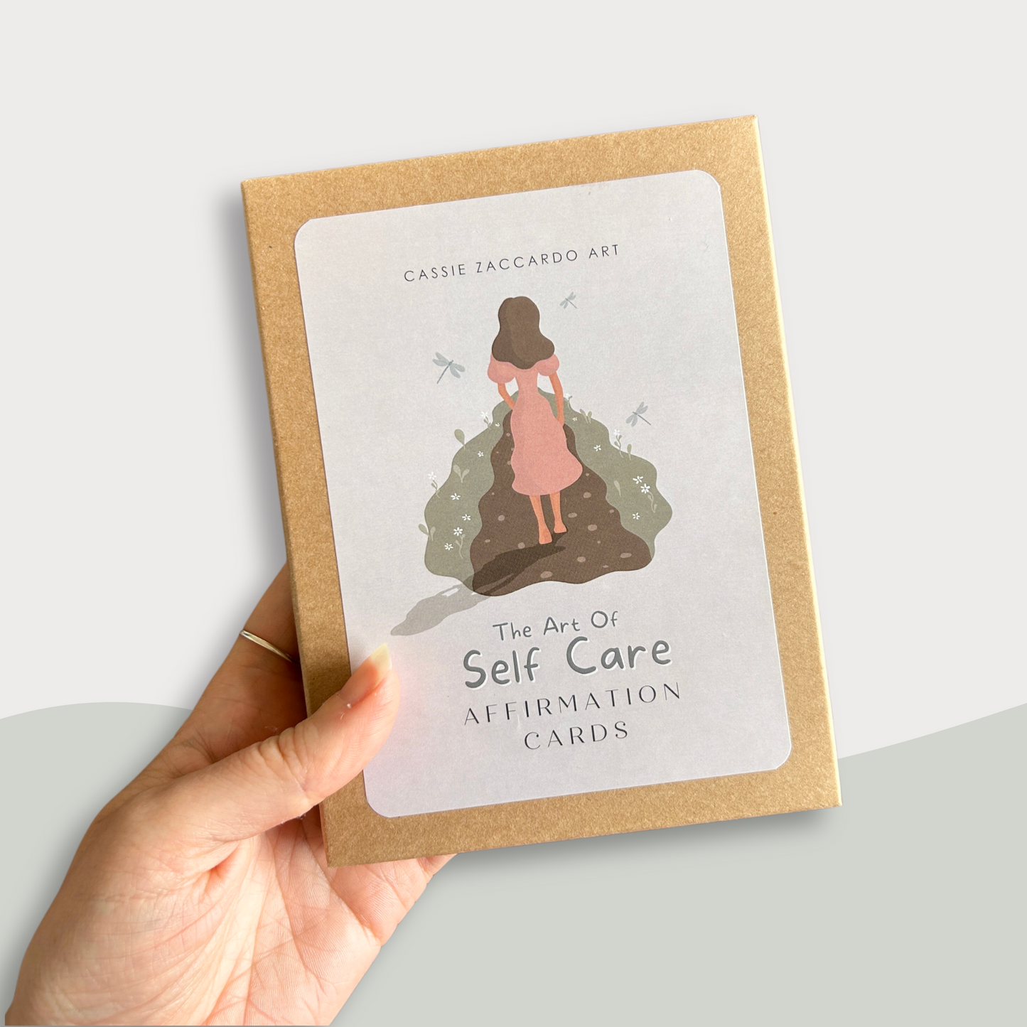 Hand holding daily affirmation card deck with wooden stand for self-care