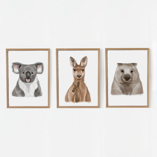 Three framed illustrations of a koala, kangaroo with joey, and wombat on a white wall.
