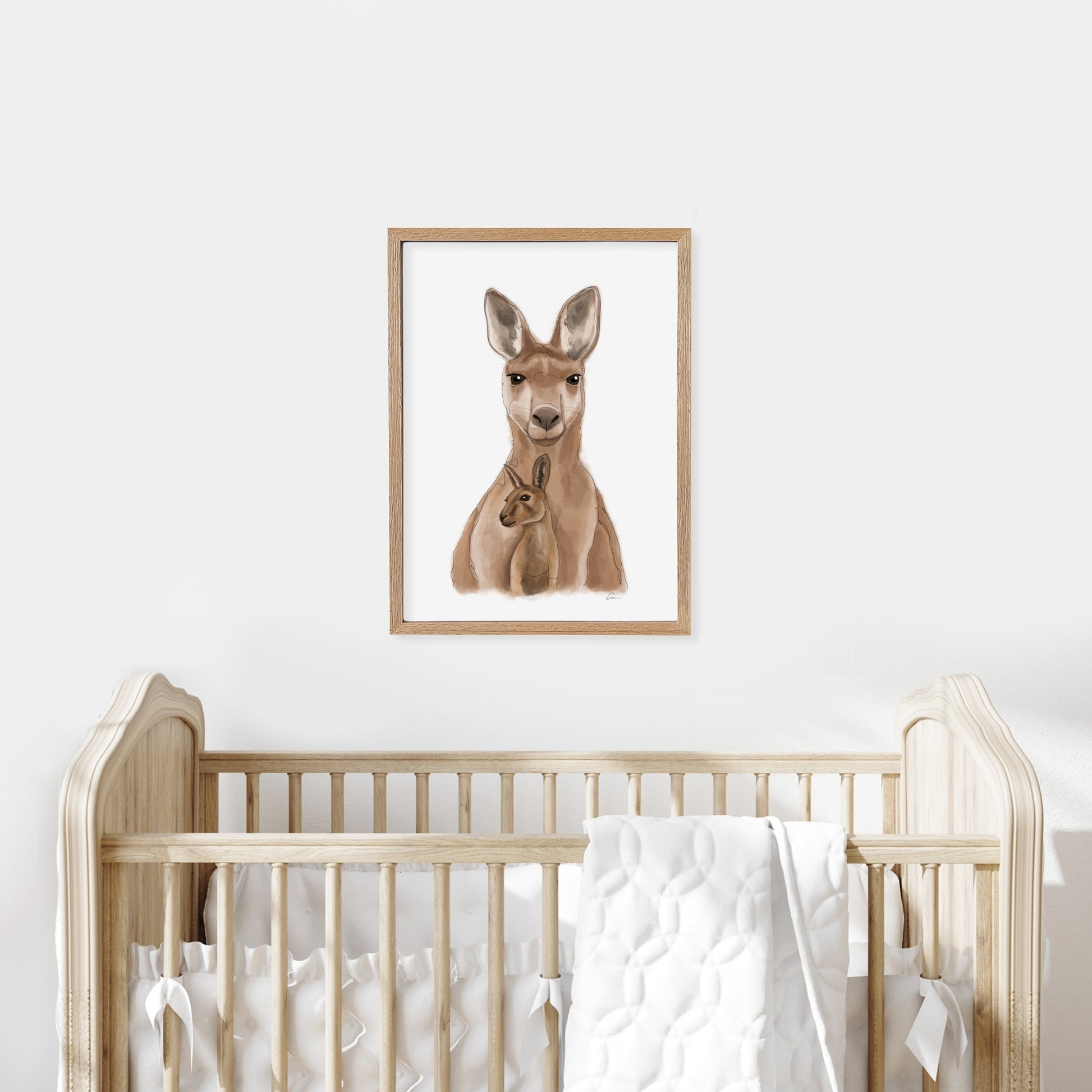 Framed illustration of a kangaroo on a wall above a cot in a baby nursery.