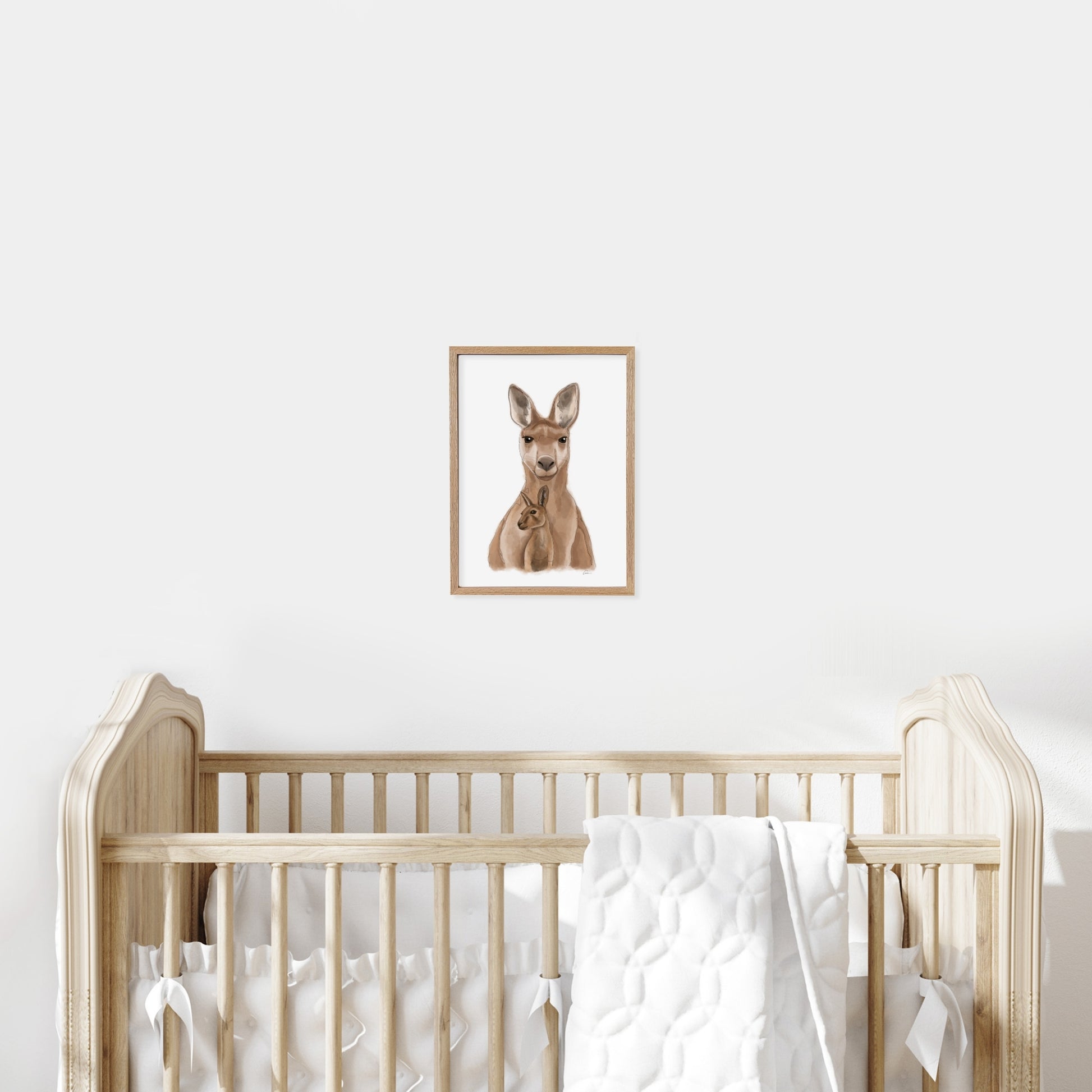 Framed illustration of a kangaroo on a wall above a cot in a baby nursery.