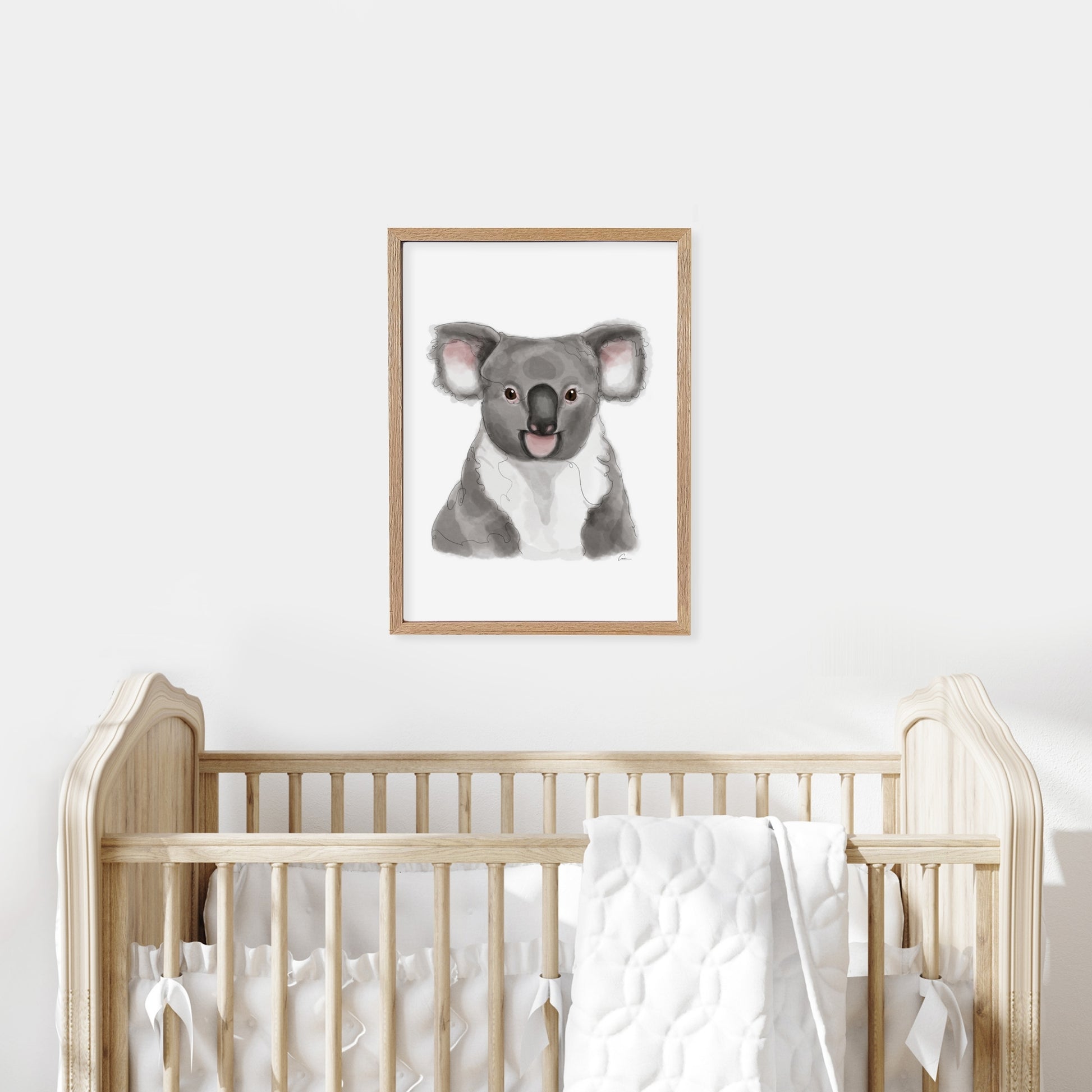 Framed illustration of a koala on a wall above a cot in a baby nursery.