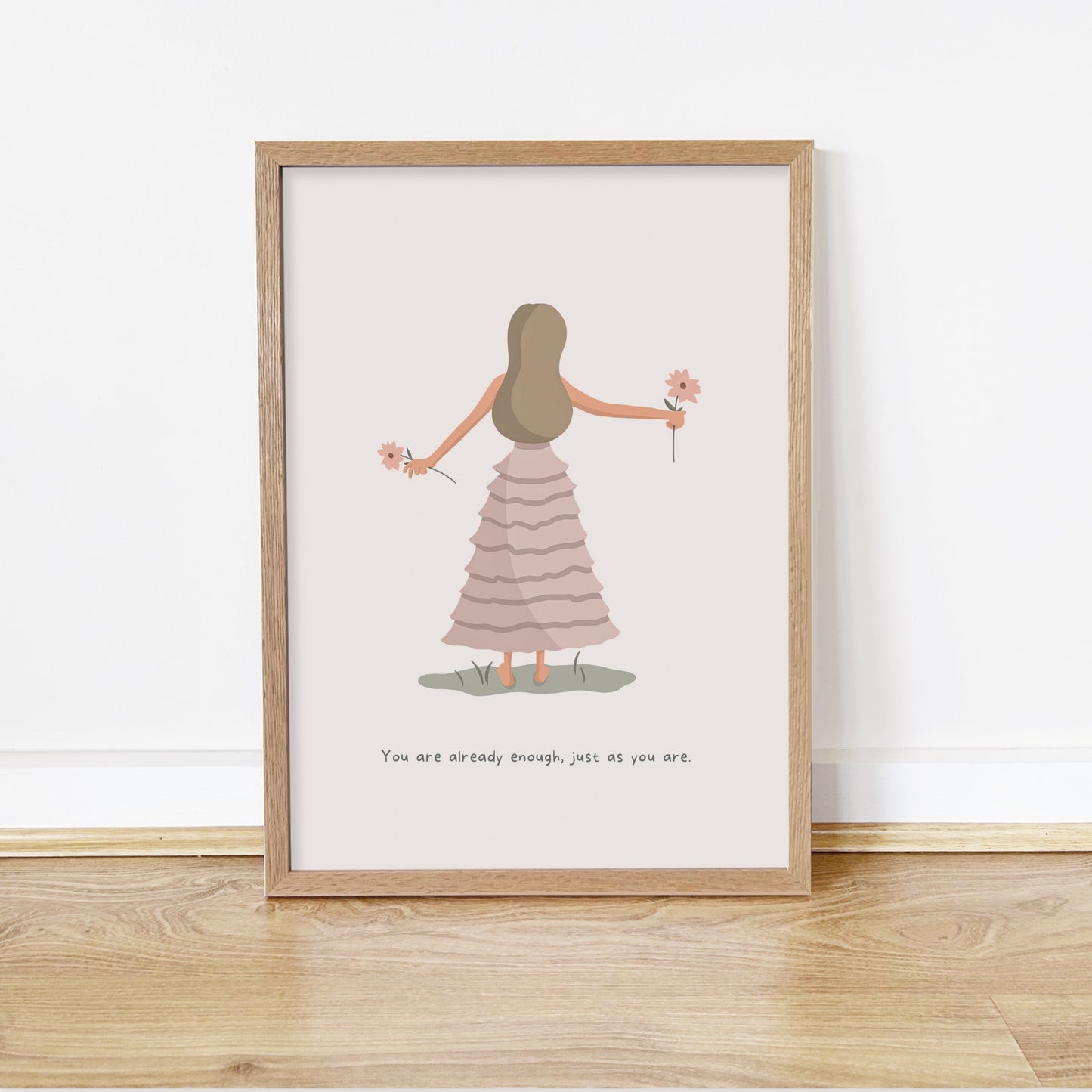 Framed artwork of a woman in a dress holding flowers on a white wall.