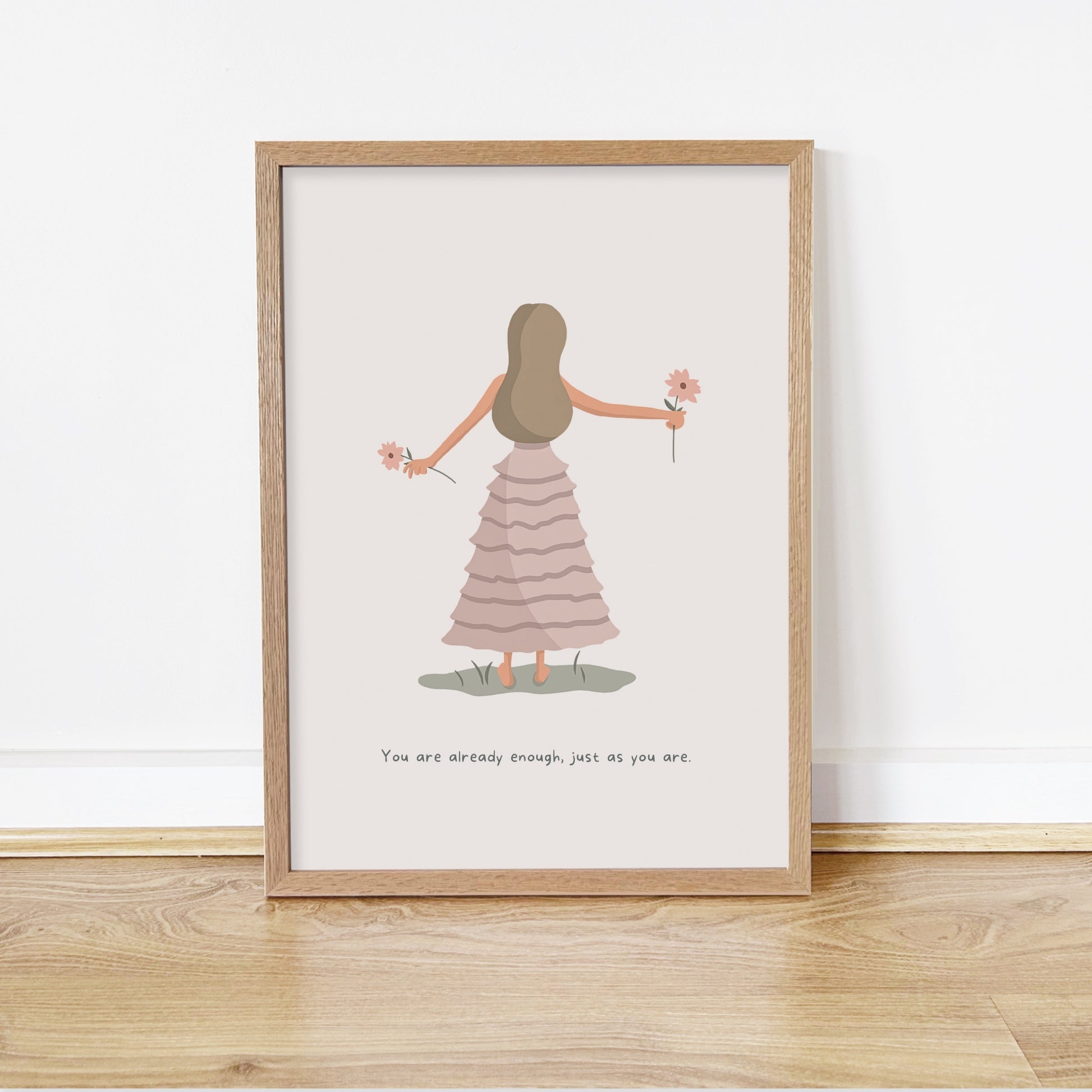 Framed artwork of a woman in a dress holding flowers on a white wall.