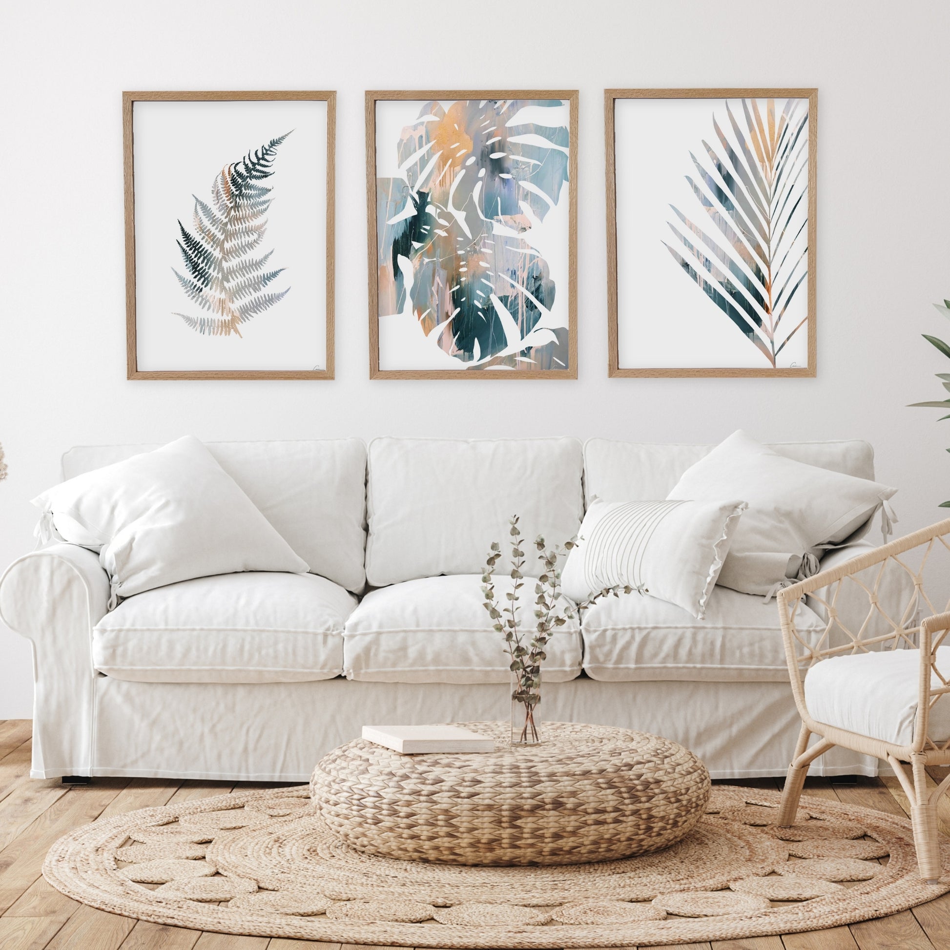 Living room with a white sofa, decorative pillows, and framed leaf art on the wall.