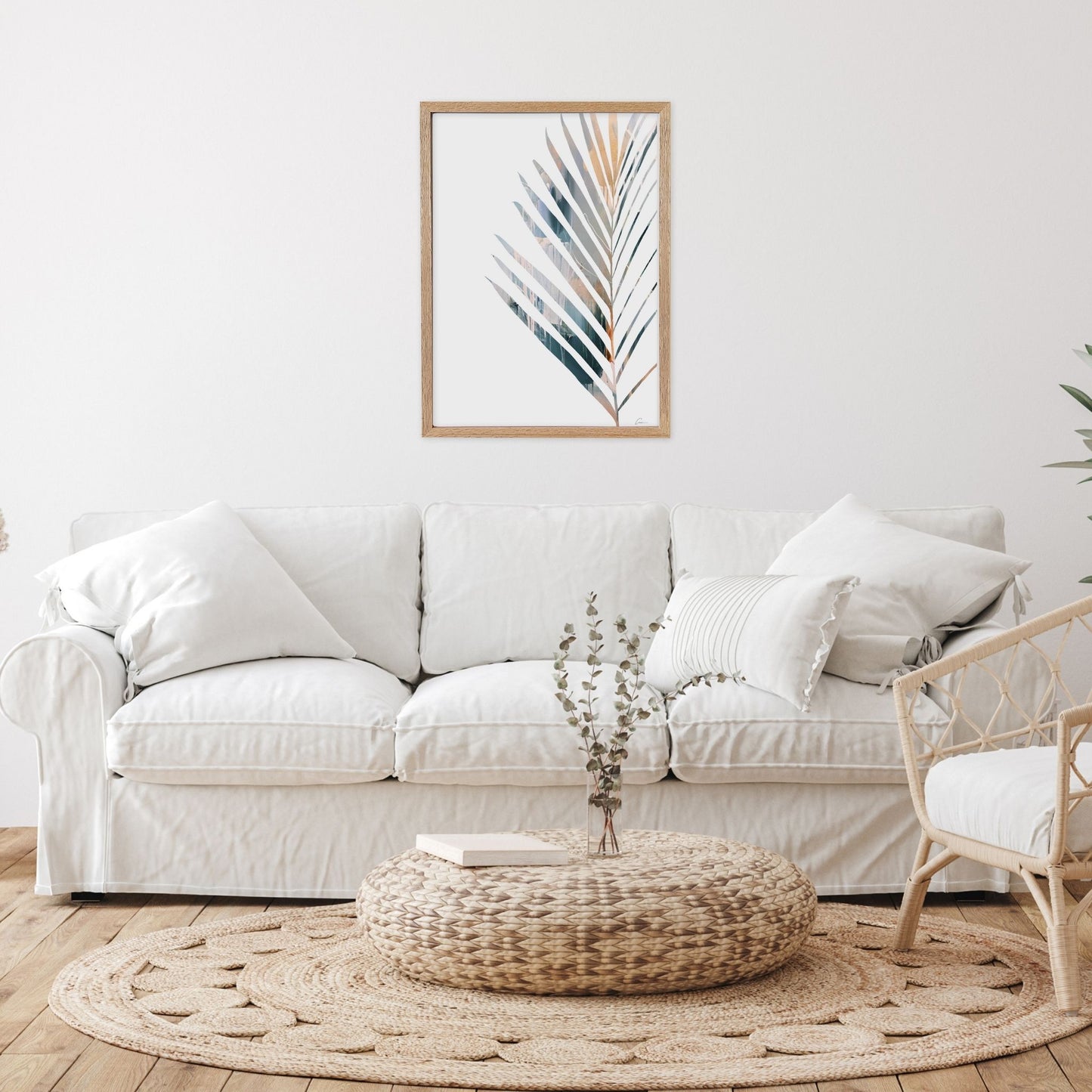 Framed artwork with Yucca leaf in Living room with a white sofa, woven ottoma