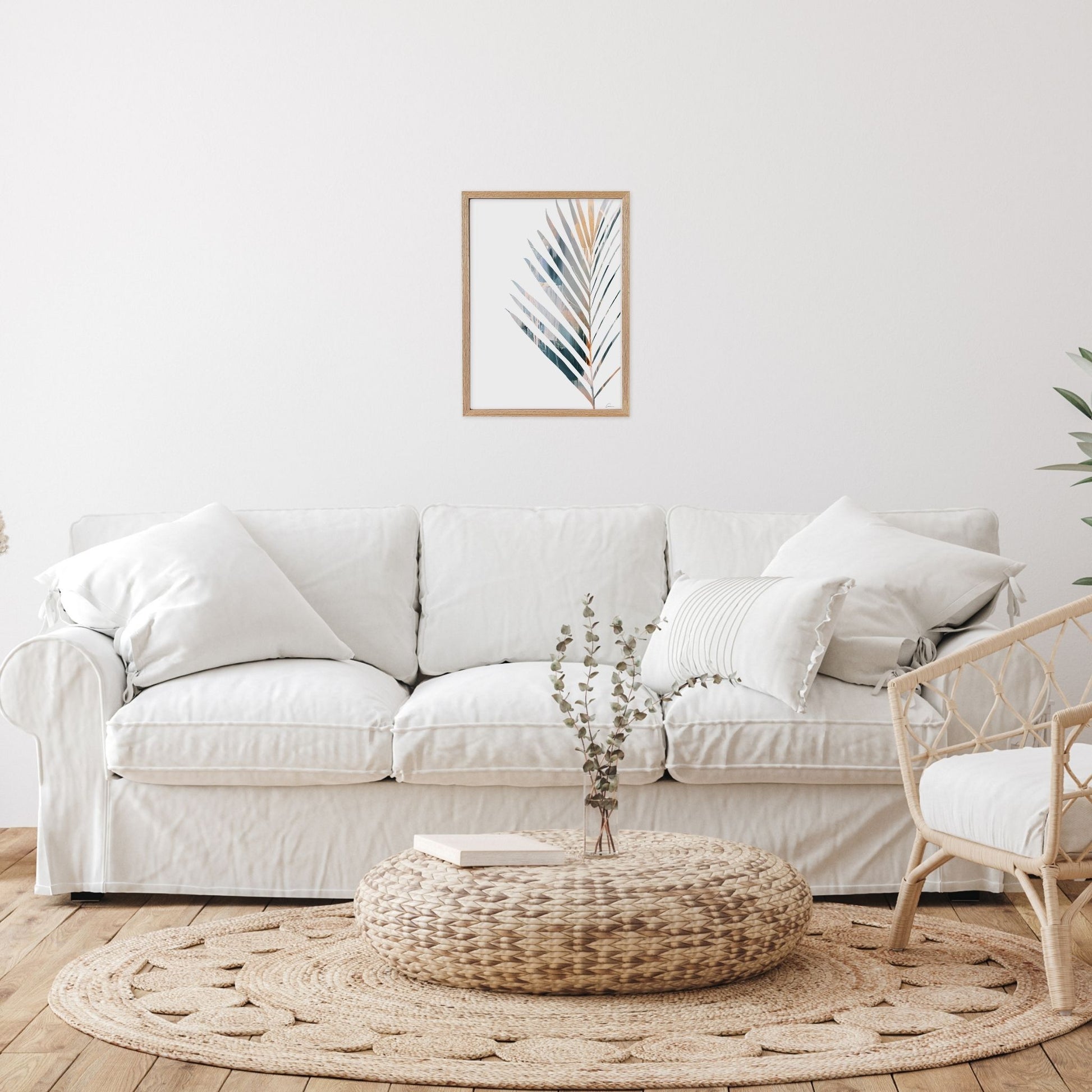 Framed artwork with Yucca leaf in Living room with a white sofa, woven ottoman, 