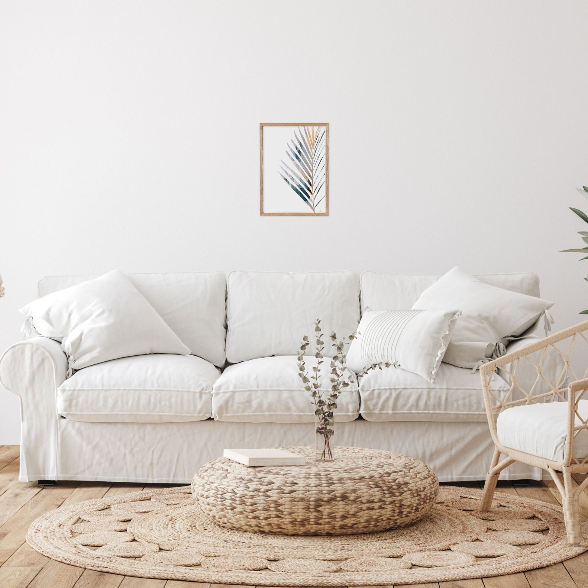 Framed artwork with Yucca leaf in Living room with a white sofa, woven ottoman, 